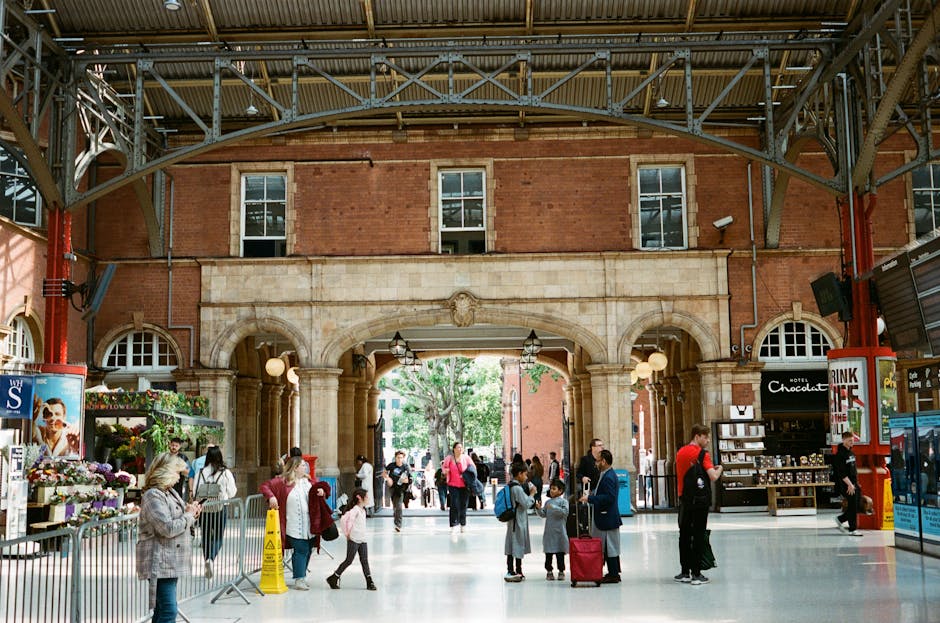 Street-level view in Marylebone showing a busy pedestrian crossing with several people walking on the sidewalk under a partly cloudy sky. The buildings feature traditional brick facades with large win